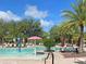 Community swimming pool with lounge chairs, tables, palm trees, and water features under blue skies at 1567 Dawnview Way, Kissimmee, FL 34744