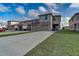 Rear exterior showcasing attached garages, green space, and long driveway at 1567 Dawnview Way, Kissimmee, FL 34744