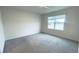 Neutral bedroom featuring plush gray carpet and a bright window at 1727 Buckeye Rd, Davenport, FL 33837