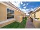 Exterior side view of a single Gathering home featuring neutral stucco, grass, brick pavers, and white trim at 1732 Pacific Rd, Kissimmee, FL 34759