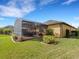 Exterior view of the backyard featuring a screened patio, lush greenery, and a well-kept lawn at 208 Almeria Way, Davenport, FL 33837