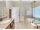 This spacious bathroom features a soaking tub, double vanity with granite countertops, and linen closet at 208 Almeria Way, Davenport, FL 33837