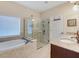 Bright bathroom with a soaking tub, walk-in shower, and a double sink vanity with granite countertops at 208 Almeria Way, Davenport, FL 33837