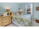 Bright bedroom with blue walls featuring a flower-patterned bedspread and a wicker dresser at 208 Almeria Way, Davenport, FL 33837