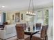 Dining room showcases a glass-topped table with wicker chairs and a modern chandelier at 208 Almeria Way, Davenport, FL 33837