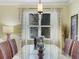 Dining room features a glass-topped table with wicker chairs and a modern chandelier at 208 Almeria Way, Davenport, FL 33837