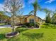 Well maintained property with manicured lawn, mature palm trees, and shrubbery at 208 Almeria Way, Davenport, FL 33837