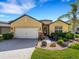 Charming home featuring a well-manicured lawn, a two-car garage, and tasteful landscaping at 208 Almeria Way, Davenport, FL 33837