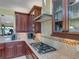 Close up on kitchen showing gas range, granite countertops, and glass door cabinets at 208 Almeria Way, Davenport, FL 33837