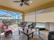 Inviting screened lanai featuring comfortable seating, ceiling fan, and views of the outdoor landscape at 208 Almeria Way, Davenport, FL 33837