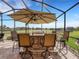 Inviting outdoor screened kitchen features a stone bar, built-in grill, and comfortable seating at 208 Almeria Way, Davenport, FL 33837