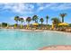 Expansive outdoor pool with lounge chairs, yellow umbrellas, and palm tree landscaping at 208 Almeria Way, Davenport, FL 33837