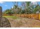 Spacious backyard featuring new wood fence, lush trees, and partially grass-covered lot at 2488 Pine Chase Cir, St Cloud, FL 34769