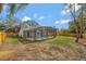 Backyard view of caged pool and covered patio with lush grass and privacy fence at 2488 Pine Chase Cir, St Cloud, FL 34769