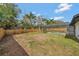 Backyard view of caged pool, covered patio and privacy fence, surrounded by trees at 2488 Pine Chase Cir, St Cloud, FL 34769