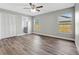 Spacious bedroom featuring wood-look floors, two windows, closet, and bathroom entry at 2488 Pine Chase Cir, St Cloud, FL 34769