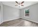 Bright bedroom with wood-look floors, ceiling fan, and natural light from a window at 2488 Pine Chase Cir, St Cloud, FL 34769