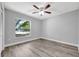 Bright bedroom with wood-look floors, ceiling fan, and natural light from a window at 2488 Pine Chase Cir, St Cloud, FL 34769