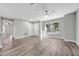 Open-concept living room with hardwood floors, white walls, ceiling fan, and a view of the front yard at 2488 Pine Chase Cir, St Cloud, FL 34769