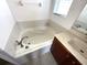 Relaxing bathtub nook with decorative tile, sink, and window for natural light at 2523 Salzburg Loop, Winter Haven, FL 33884