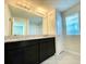 Bathroom with double vanity, granite countertop, and large mirror at 2595 Buena View Road, Kissimmee, FL 34746