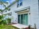 Townhouse exterior with sliding glass door, small patio, and white siding at 2595 Buena View Road, Kissimmee, FL 34746