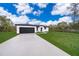 Beautiful home with a black garage door, white paint and long concrete driveway at 2609 Sw 154Th Lane, Ocala, FL 34473