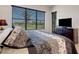 Bedroom view showing dark wood dresser, large window with shades, and patterned bedding at 280 Del Sol Ave, Davenport, FL 33837