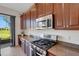 Kitchen with dark wood cabinetry, granite counters, and stainless steel appliances at 280 Del Sol Ave, Davenport, FL 33837