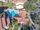 Aerial view of community featuring buildings with red tile roofs, pool, pond, landscaping, and ample parking at 3004 Parkway Blvd # 202, Kissimmee, FL 34747