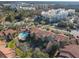 Aerial view of community featuring buildings with red tile roofs, pool, pond, landscaping, and ample parking at 3004 Parkway Blvd # 202, Kissimmee, FL 34747