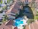 Aerial view of community featuring buildings with red tile roofs, pool, pond, landscaping, and ample parking at 3004 Parkway Blvd # 202, Kissimmee, FL 34747