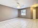 Neutral bedroom featuring tile flooring, neutral paint, a ceiling fan, a window, and a closet at 3004 Parkway Blvd # 202, Kissimmee, FL 34747