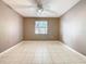 A bedroom with a ceiling fan, window, tile flooring, and neutral wall color at 3004 Parkway Blvd # 202, Kissimmee, FL 34747