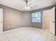 A bedroom featuring a ceiling fan, tile flooring, and neutral wall color at 3004 Parkway Blvd # 202, Kissimmee, FL 34747