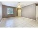 Neutral living room with tile floor, ceiling fan, and a white front door at 3004 Parkway Blvd # 202, Kissimmee, FL 34747