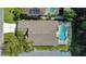 Overhead view of the house featuring a pool, a well-manicured lawn, and a driveway leading to the residence at 3048 Stillwater Dr, Kissimmee, FL 34743