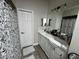 Bathroom with dual sinks, framed mirrors, and white cabinets at 3048 Stillwater Dr, Kissimmee, FL 34743