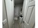 Hallway with wood-look floors, white doors, and access to a bathroom at 3048 Stillwater Dr, Kissimmee, FL 34743