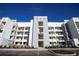 Modern four-story apartment building with balconies and well-maintained landscaping on a sunny day at 3120 Paradox Cir # 204, Kissimmee, FL 34746