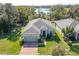 Aerial view of home with lush landscaping, a brick driveway, and a tranquil lake in the background at 3204 Wauseon Dr, St Cloud, FL 34772