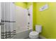 Bright bathroom with a bathtub and shower combination, toilet, and lime green walls at 3204 Wauseon Dr, St Cloud, FL 34772