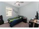 Cozy bedroom featuring a ceiling fan, a comfortable bed, and natural light from the window at 3204 Wauseon Dr, St Cloud, FL 34772