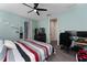 This bedroom has carpet, a ceiling fan, a television on a dresser, and a work area at 3204 Wauseon Dr, St Cloud, FL 34772