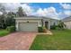 Lovely single-story home with a brick driveway, two-car garage, and neatly trimmed green landscaping at 3204 Wauseon Dr, St Cloud, FL 34772