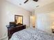 Cozy bedroom featuring neutral paint, a ceiling fan, closet, and a dresser with a large mirror at 331 Henley Cir, Davenport, FL 33896