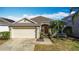 Inviting single-Gathering home featuring a two-car garage, manicured shrubs, and a warm, welcoming entrance at 331 Henley Cir, Davenport, FL 33896