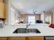 Kitchen sink with view into the living room with ceiling fan and sliding door to pool at 331 Henley Cir, Davenport, FL 33896