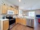 The bright kitchen features stainless steel appliances and opens into the living room with a ceiling fan at 331 Henley Cir, Davenport, FL 33896