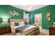 Elegant bedroom with a king-size bed, vibrant green walls, and modern decor, creating a comfortable and stylish retreat at 3348 Lilac Way, Davenport, FL 33897